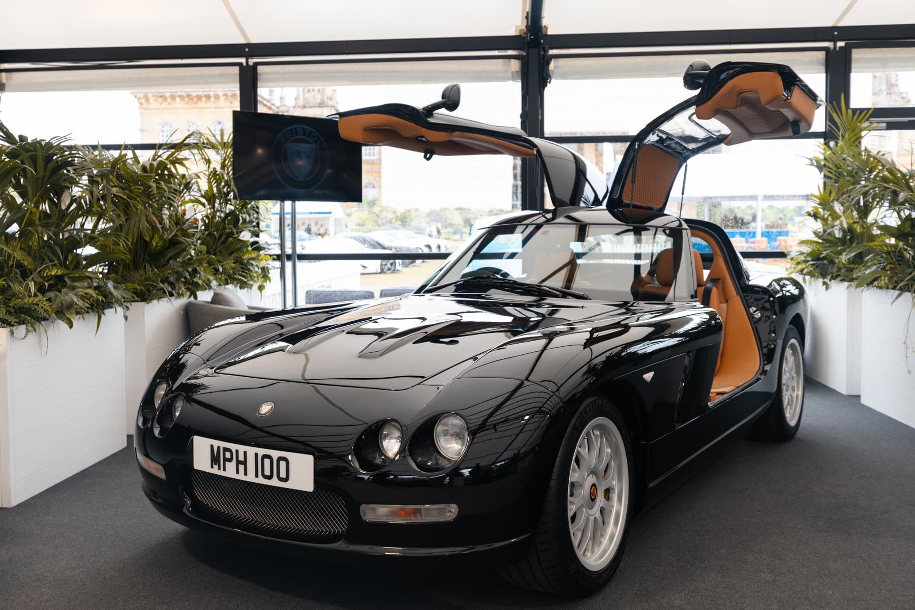 The black Bristol Fighter in The Gallery at Salon Privé 2026 with both gullwing doors raised